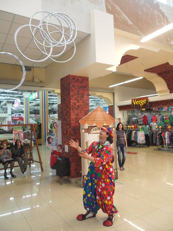 клоун жонглиреут кольцами