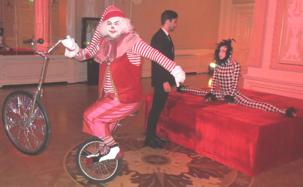 загримированный клоун на моноцикле