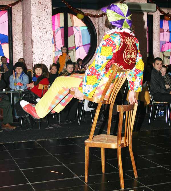 клоун балансирует на стульях