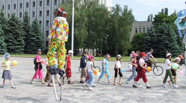 клоун на ходулях на площади