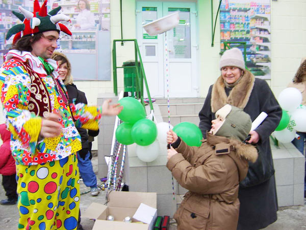 клоун раздает шарики посетителям аптеки