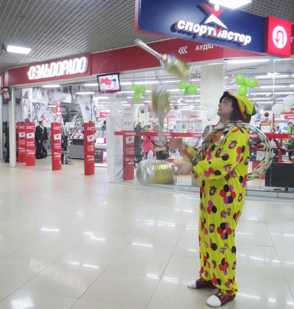 клоун жонглирует перед магазином