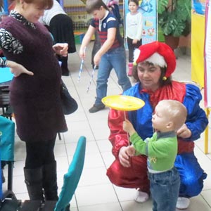 Ребенок держит тарелочку на палочке с клоуном