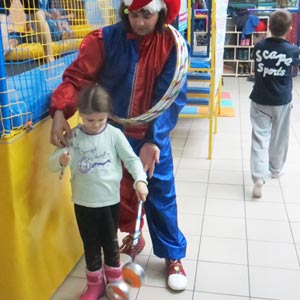 клоун учит ребенка жонглировать