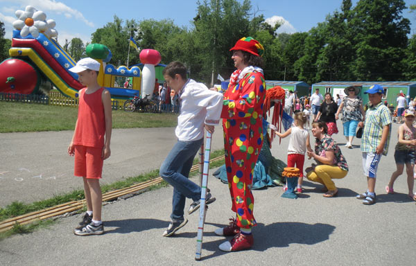 дети играют с клоуном на массовом гулянье