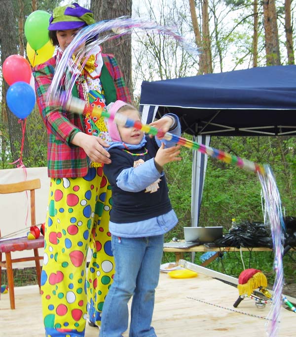 клоун учит детей крутить палку