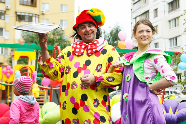 Клоун и аниматоры с детьми на детской площадке