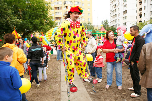 Клоун ходулист на детской площадке