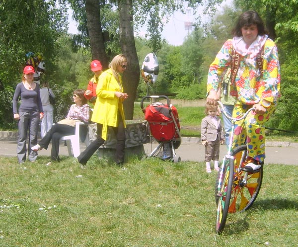 Моноцикл клоуна на зеленой траве зоопарка