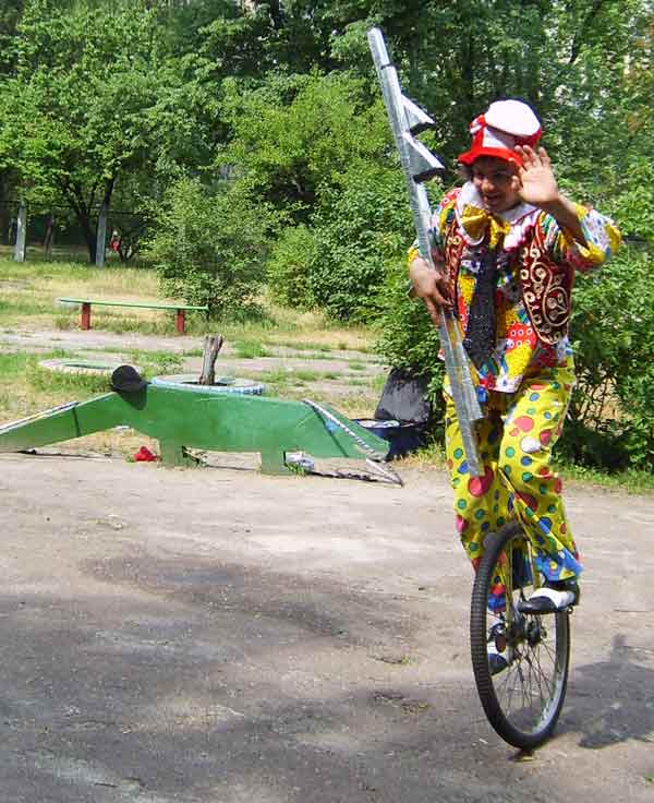 клоун на моноцикле с ходулями