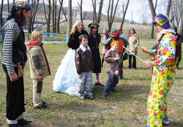 клоун жонглирует перед детьми на воздухе