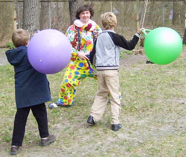 дети с клоуном бросаются мячами