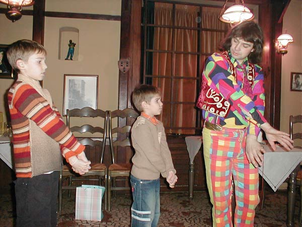 клоун показывает детям фокусы