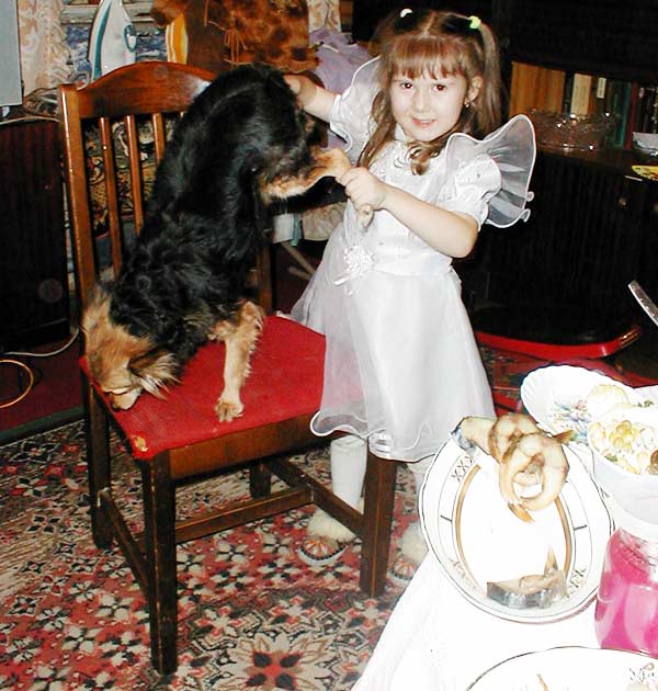 девочка держит собачку за лапы