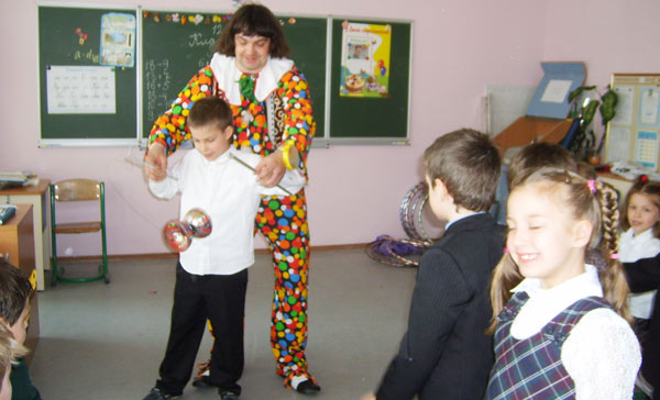 клоун учит жонглировать детей в классе