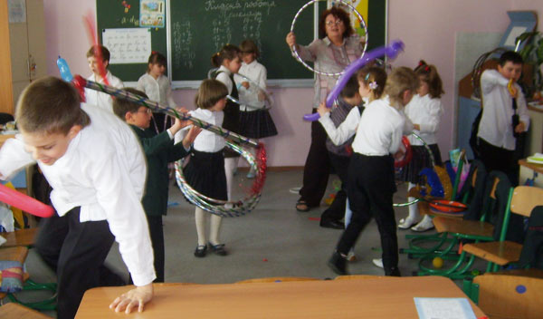 дети в школе играют с клоуном
