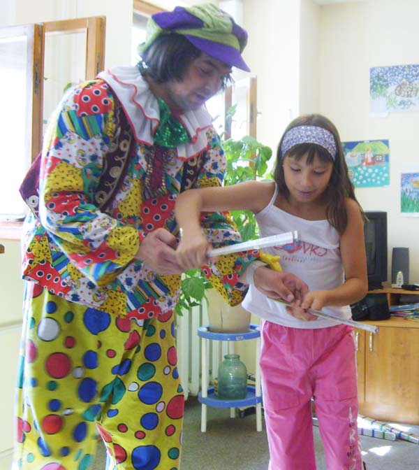 клоун учит девояку жонглировать