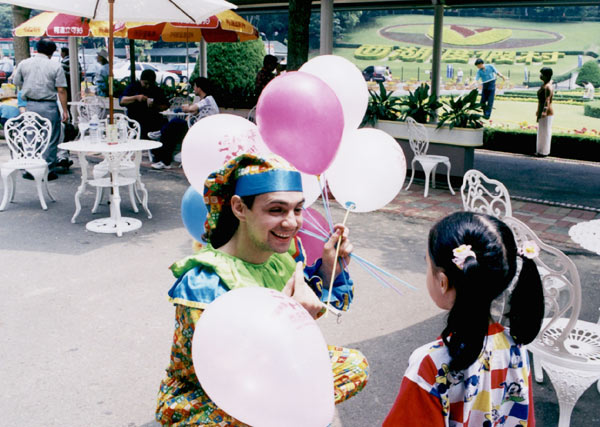 клоун раздает шарики детям