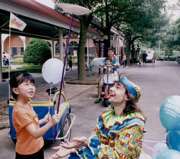 клоун в парке развлекает детей